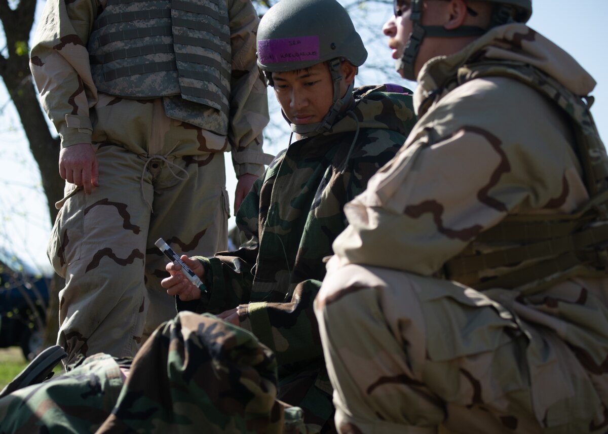Senior Airman Atichai Kaewdarunee, 22nd Civil Engineer Squadron heating, ventilation and air conditioning technician, and Senior Airman Jason Hurd, 22nd CES electrical systems technician, deliberate on using an epinephrine injector in a simulated medical emergency during the 22nd CES Battle of the Bulls competition at McConnell Air Force Base, Kansas, April 17, 2025. As part of the competition, Airmen were given different medical scenarios to test their knowledge. (U.S. Air Force photo by Senior Airman Amelio Brown)