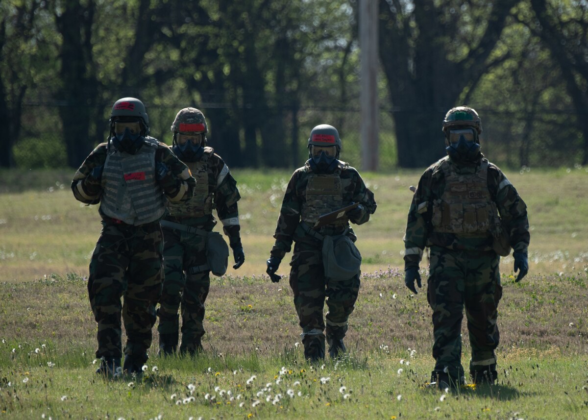 Airmen from the 22nd Civil Engineer Squadron conduct a simulated post-action reconnaisance (PAR) sweep during the 22nd CES Battle of the Bulls competition at McConnell Air Force Base, Kansas, April 17, 2025. The teams suited up in mission-oriented protective posture gear to perform the PAR sweeps. (U.S. Air Force photo by Senior Airman Amelio Brown)