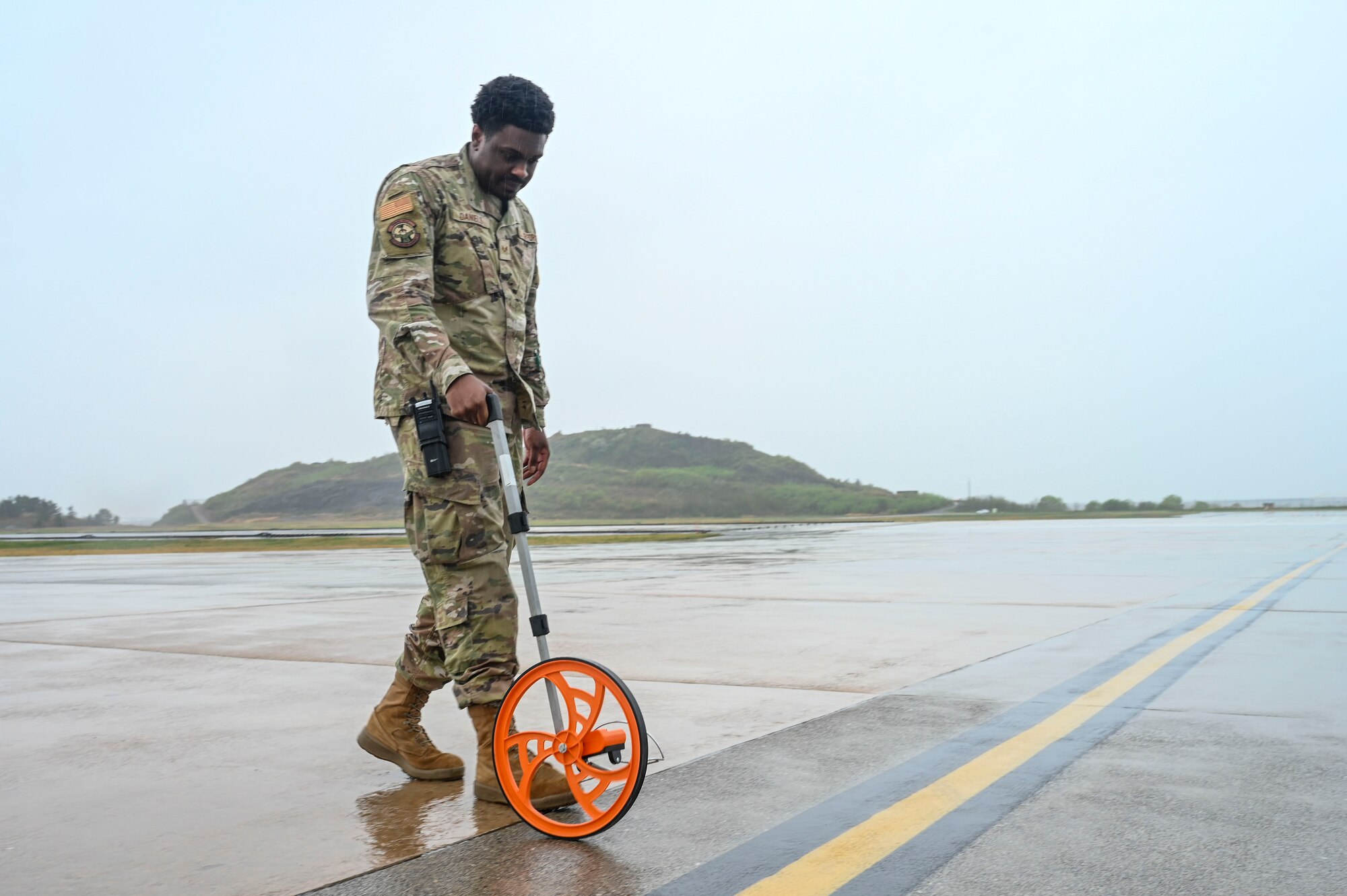 Senior Airman Morisse Daniels, 8th Operations Support Squadron airfield management operations supervisor, measures the width of a taxiway during Freedom Flag 25-1 at Kunsan Air Base, Republic of Korea, April 22, 2025.