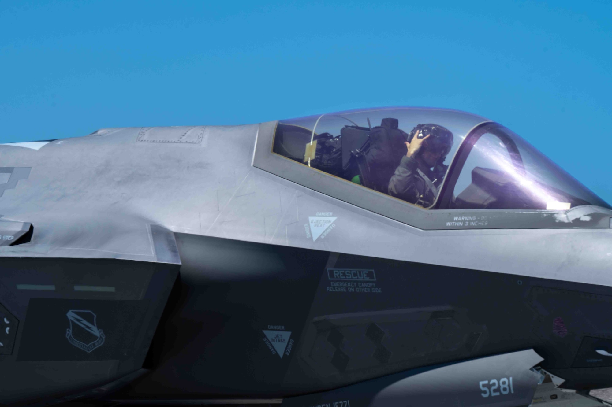 Pilot throw up a hand sign while taxiing on the flight line