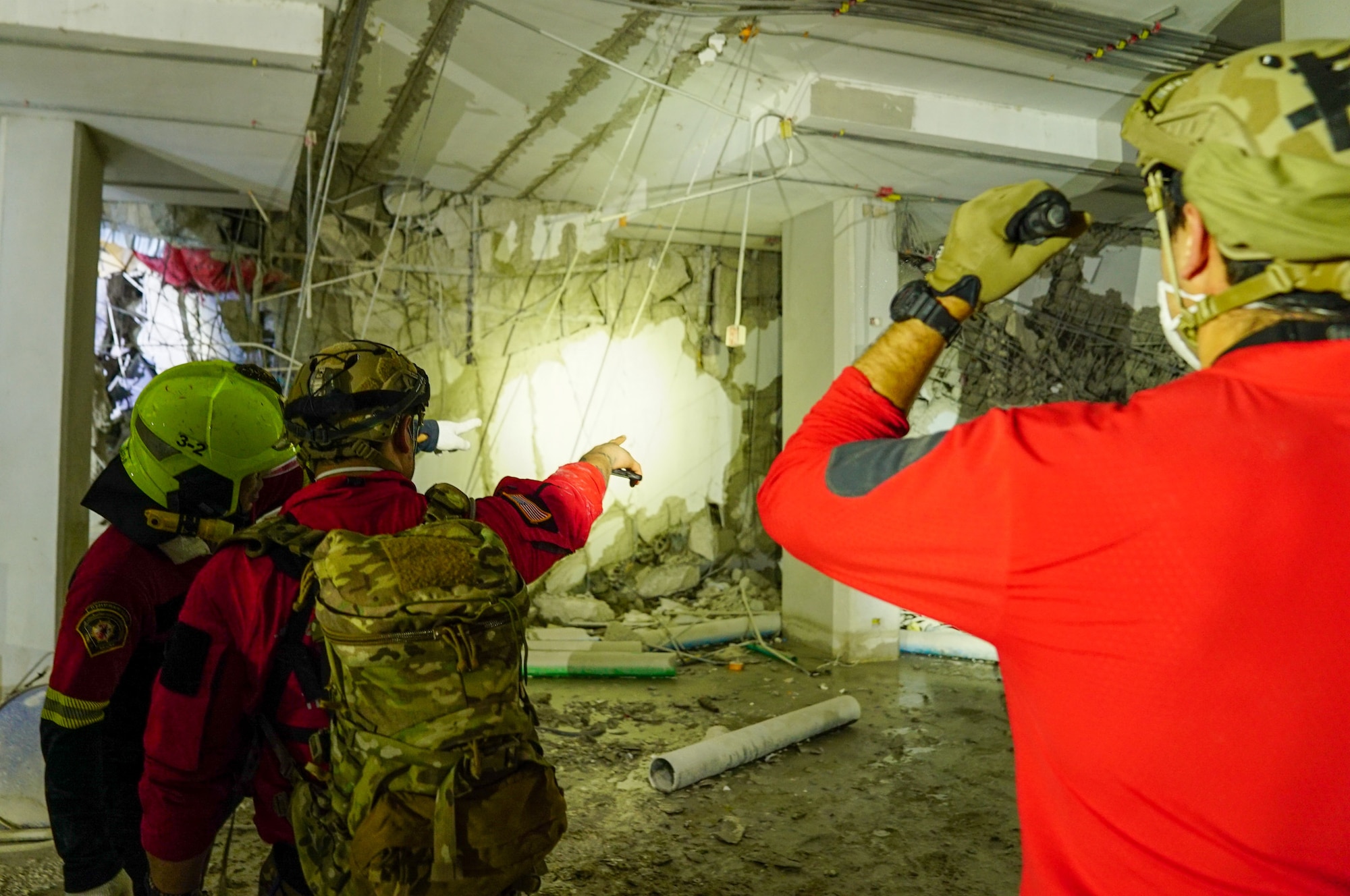 Military members sign light on rubble from a collapsed building.