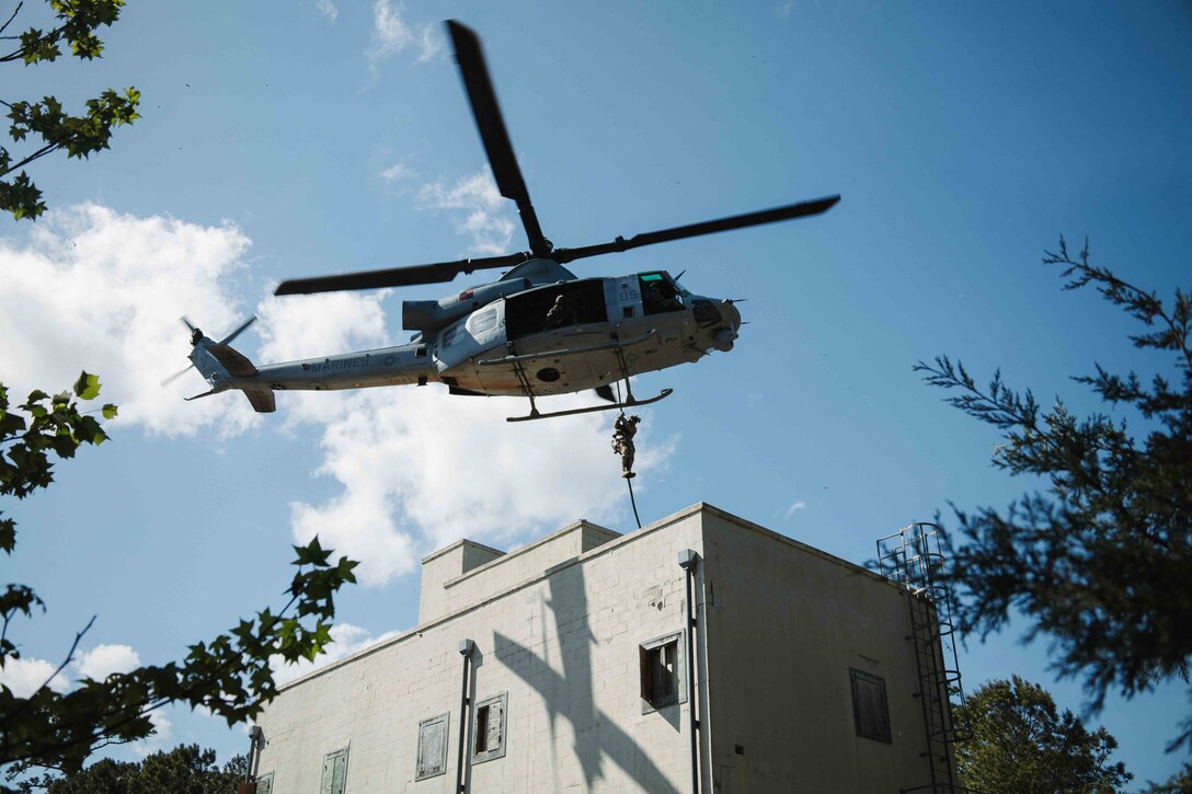 A U.S. Marine with Charlie Company, 2nd Battalion, 2nd Marine Regiment fast-ropes from a UH-1Y Venom helicopter with Marine Light Attack Helicopter Squadron (HMLA) 167 during a limited scale raid exercise at Stone Bay in Camp Lejeune, North Carolina on April 10, 2025. 2nd Battalion, 2nd Marine Regiment conducted raid training to practice and refine techniques and procedures in preparation for potential future missions as the ground combat element of the Special Purpose Marine Air-Ground Task Force – Alert Contingency MAGTF (SPMAGTF-ACM). (U.S. Marine Corps photo by Sgt. Jorge Borjas)
