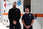Air Force paramedics pose in front of ambulance