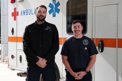 Air Force paramedics pose in front of ambulance