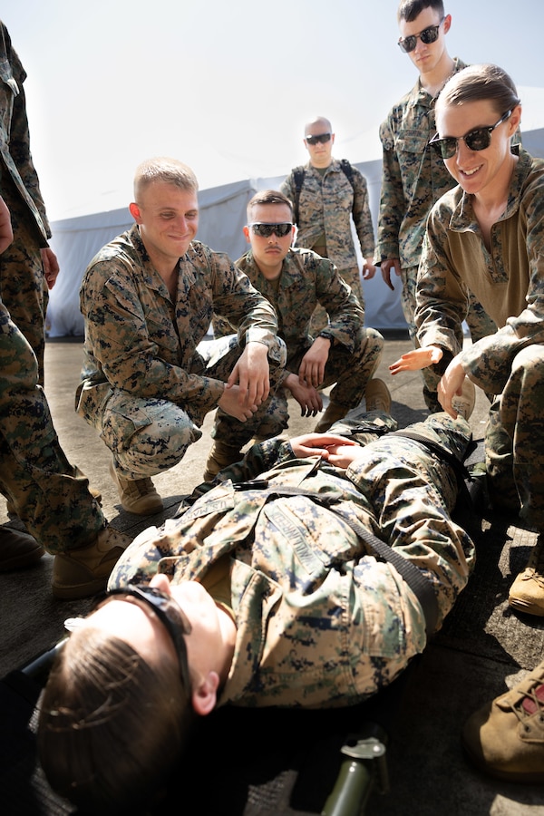 U.S. Navy Hospital Corpsman 1st Class Sara Vanharen with Marine Aircraft Group 24, 1st Marine Aircraft Wing, III Marine Expeditionary Force, demonstrates proper use of a gurney to U.S. Marines with 4th Law Enforcement Battalion, Force Headquarters Group, Marine Force Reserve before the practical application portion of a casualty evacuation drill at Cagayan North International Airport , Lal-Lo, Luzon, Philippines, on April 18, 2025 in support of Exercise Balikatan 25. Balikatan is a longstanding annual exercise between the Armed Forces of the Philippines and U.S. military designed to strengthen our ironclad alliance, improve our capable combined force, and demonstrate our commitment to regional security and stability. (U.S. Marine Corps photo by Gunnery Sgt. Kai W. Huber)