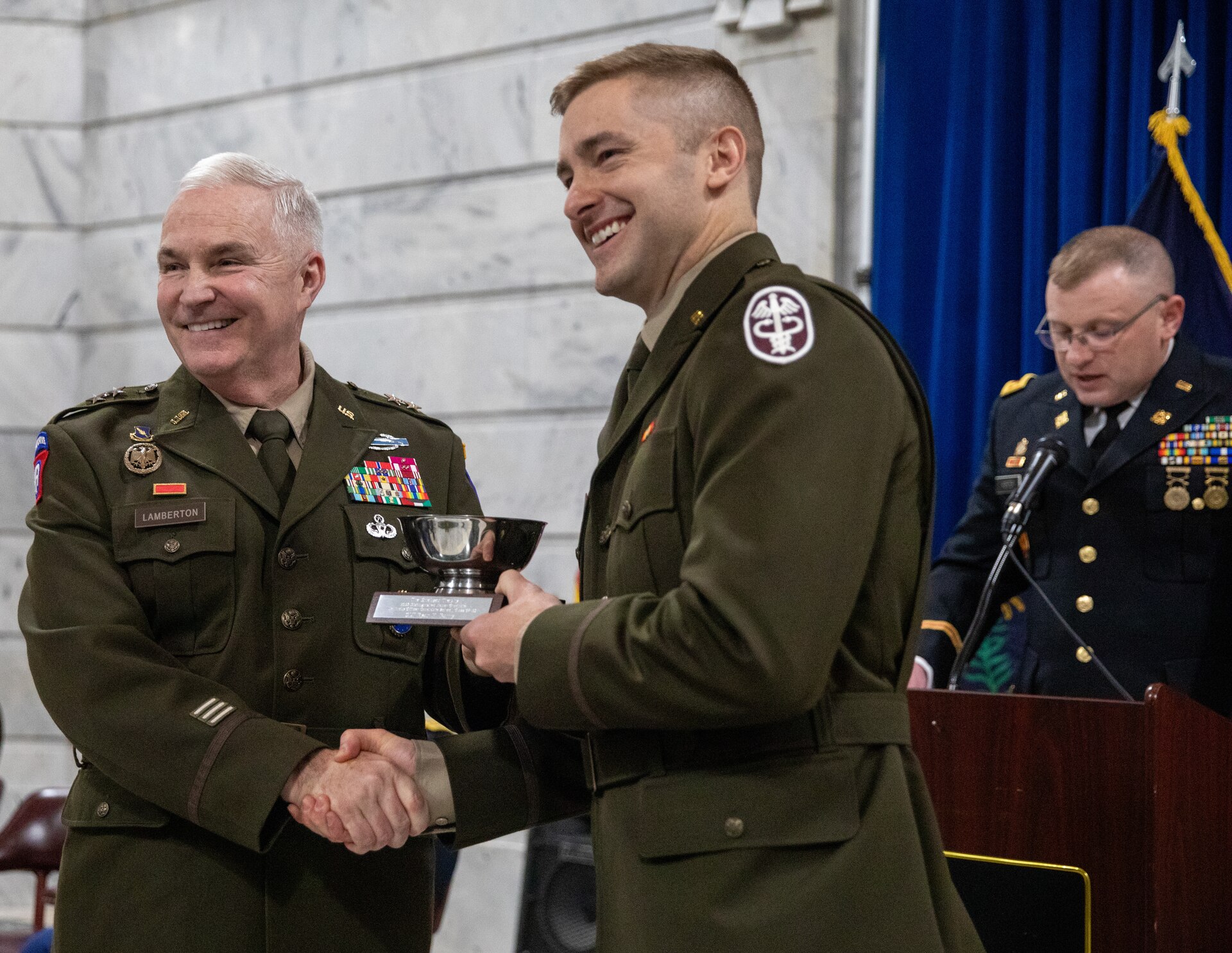 U.S. Army Maj. Gen. Haldane Lamberton, Kentucky adjutant general, presents the Erickson Trophy to 2nd Lt. Ryan Barry during the OCS Class 67-25 graduation ceremony in the Kentucky State Capitol Rotunda in Frankfort, Kentucky, April 12, 2025.
