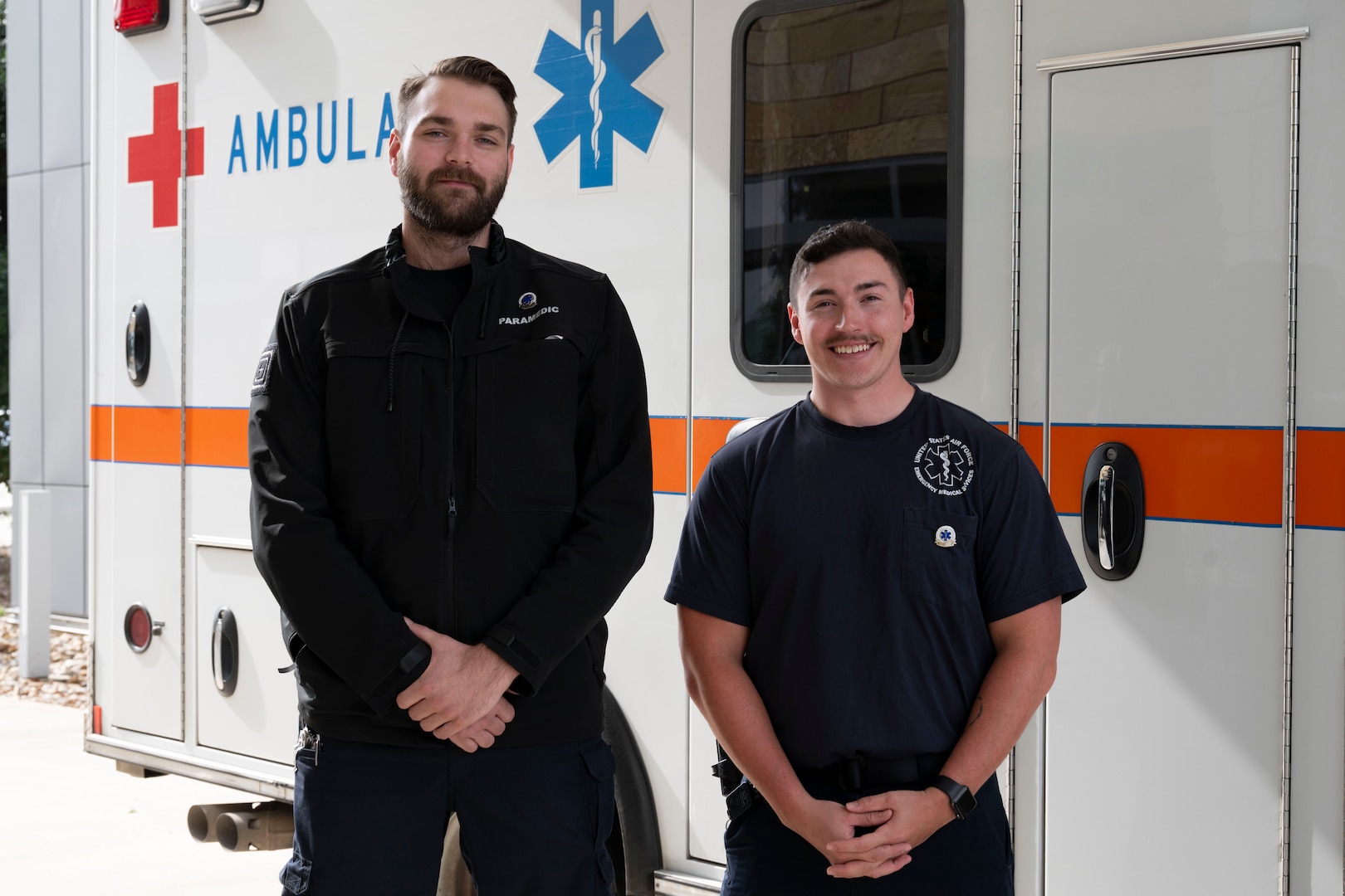Air Force paramedics pose in front of ambulance