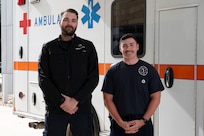 Air Force paramedics pose in front of ambulance