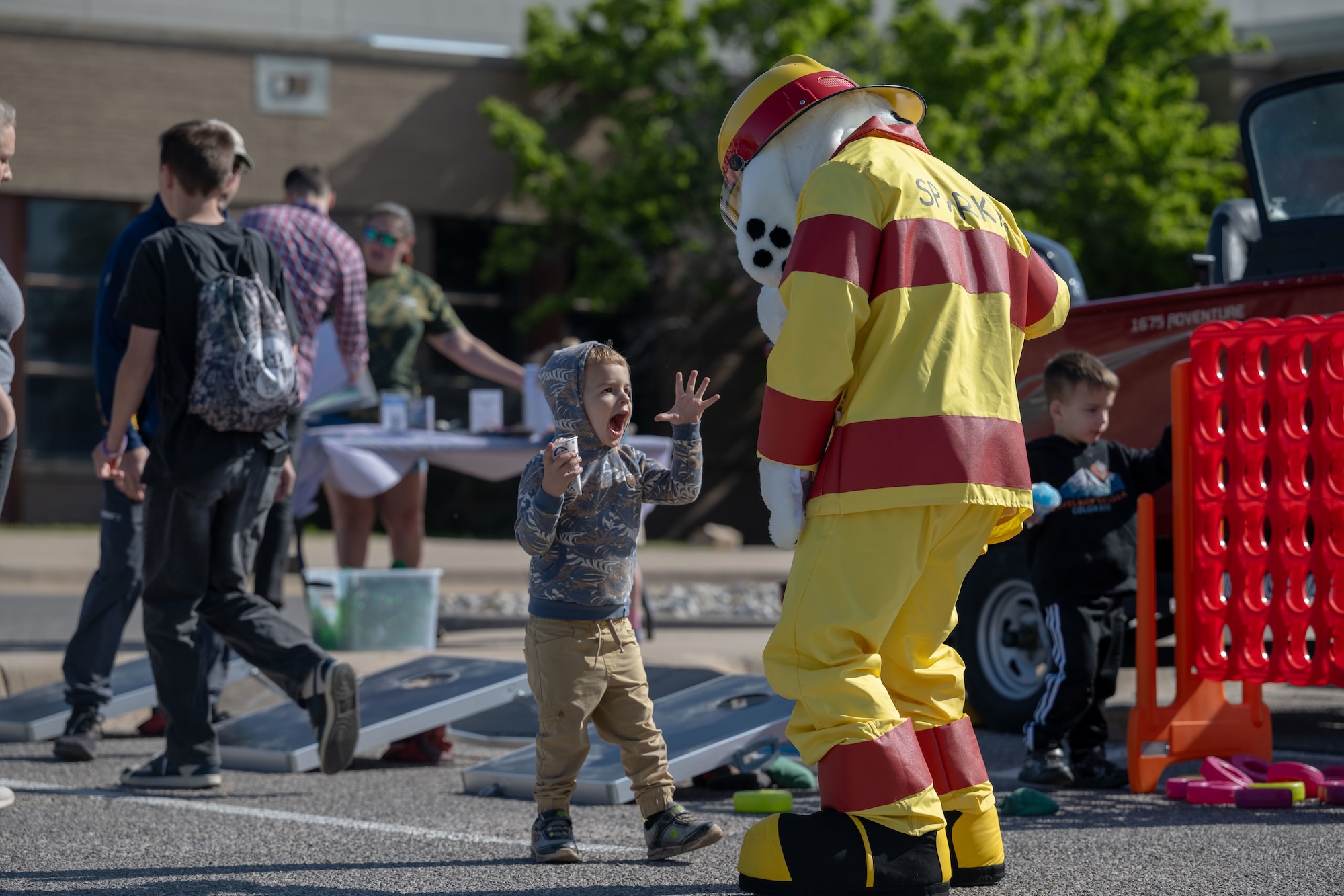 Sparky the Fire Dog meets with a Family Festival of Fun attendant at McConnell Air Force Base, Kansas, April 12, 2025. The festival is an annual event hosted by the 22nd FSS in honor of Month of the Military Child. (U.S. Air Force photo by Airman 1st Class Paula Arce)