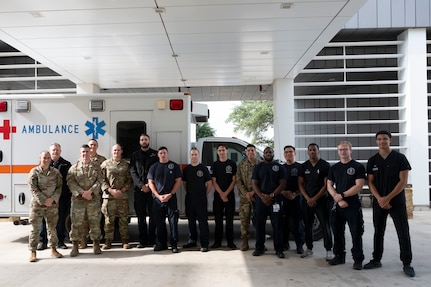 Fifteen staff members from the U.S. Air Force's Wilford Hall Emergency Department team pose in front of an ambulance