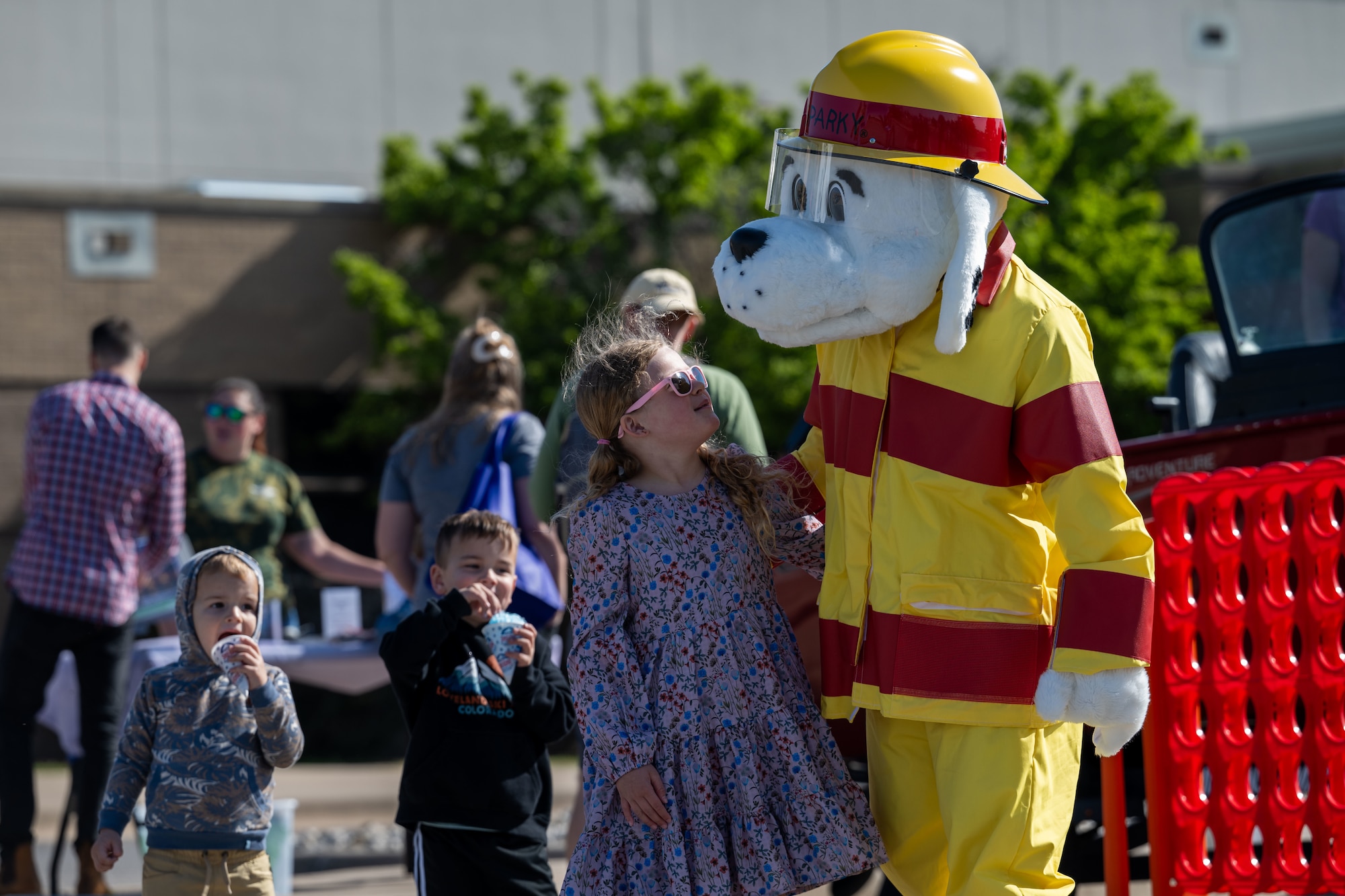 Sparky the Fire Dog meets with a Family Festival of Fun attendant at McConnell Air Force Base, Kansas, April 12, 2025. Sparky, the official mascot of the National Fire Protection Association, greeted children during the festival to promote fire safety education. (U.S. Air Force photo by Airman 1st Class Paula Arce)