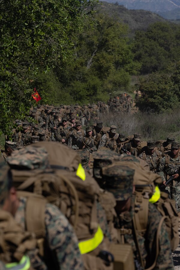 U.S. Marines and Sailors with Headquarters and Service Battalion, 1st Marine Logistics Group conduct a 10k hike on Marine Corps Base Camp Pendleton, California, April 11, 2025. The hike was the third iteration of a series and was conducted to condition the Marines and Sailors and to improve the battalion's unit cohesion and combat readiness. (U.S. Marine Corps photo by Lance Cpl. Desiree Ruiz)