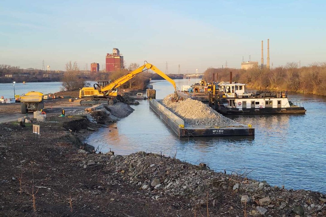 Rock which has been excavated from the river channel for construction of the Brandon Road Interbasin Project near Joliet, Illinois, is unloaded from a barge and placed into trucks for use in another area of the project.