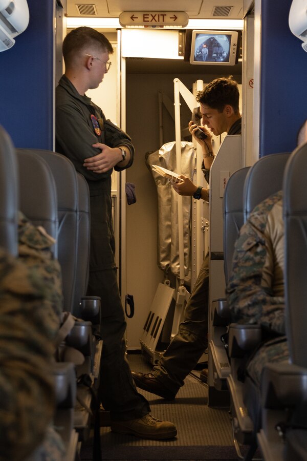 U.S. Marine Corps Sgt. David Craven, left, a C-40A load master, and Lance Cpl. Kody Nowicki, a second loadmaster, both with Marine Transport Squadron 1, Marine Aircraft Group 41, 4th Marine Aircraft Wing, Marine Forces Reserves, announce a notional egress rehearsal aboard a C-40A assigned to VMR-1, while flying over the Arafura Sea, May 1, 2024. VMR-1 transported Marines and Sailors with Marine Rotational Force – Darwin 24.3 to Papua New Guinea in support of a humanitarian assistance and disaster relief exercise. The HADR exercise will be conducted in coordination with the Papua New Guinea Defence force and U.S. Embassy in Port Moresby, with a focus on projecting select role II medical, logistics, and Marine Air-Ground Task Force command and control capabilities off-continent, to validate HADR training and readiness. Craven is a native of Texas. Nowicki is a native of Minnesota. (U.S. Marine Corps photo by Cpl. Migel A. Reynosa)