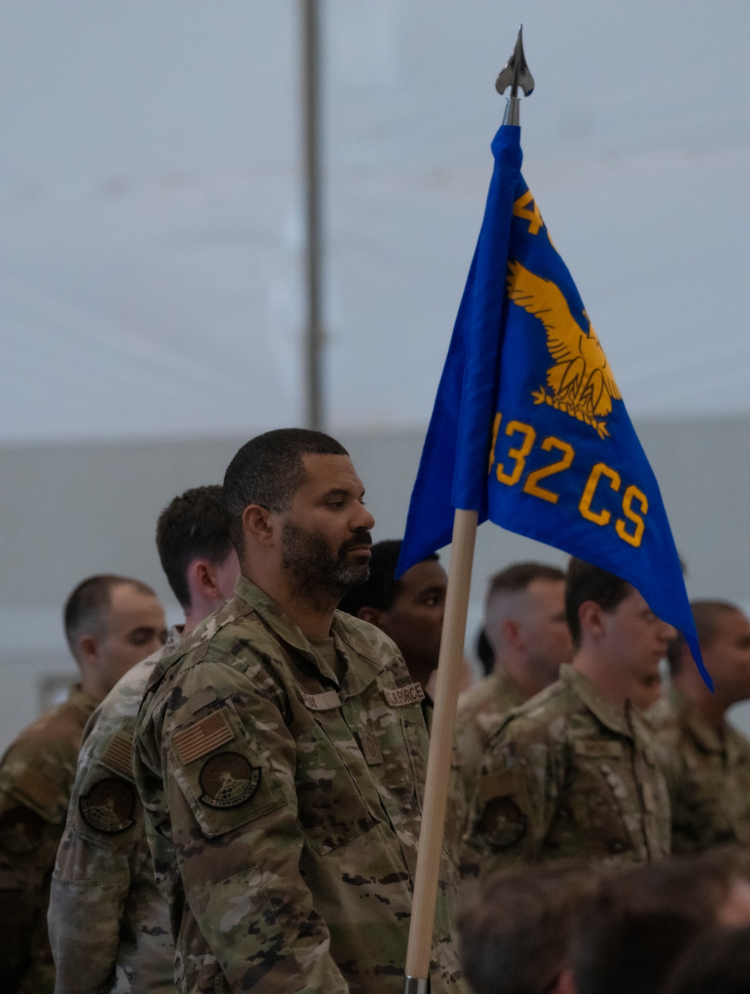 An airman stands with a guidon flag.