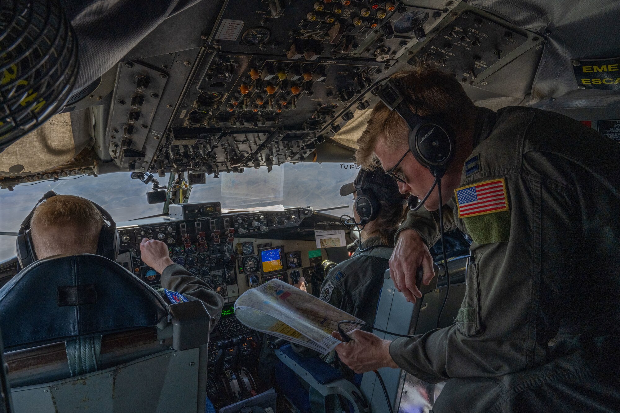 (From left) Capt. Luke Hartings, Capt. Augustus Bates and Capt. Rachel Kelly, 350th Air Refueling Squadron KC-135 Stratotanker pilots, communicate during a low-level mission April 16, 2025, over California. Bates and Hartings gained tactics experience on the flight in preparation for U.S. Air Force Weapons School. (U.S. Air Force photo by Airman 1st Class Paula Arce)