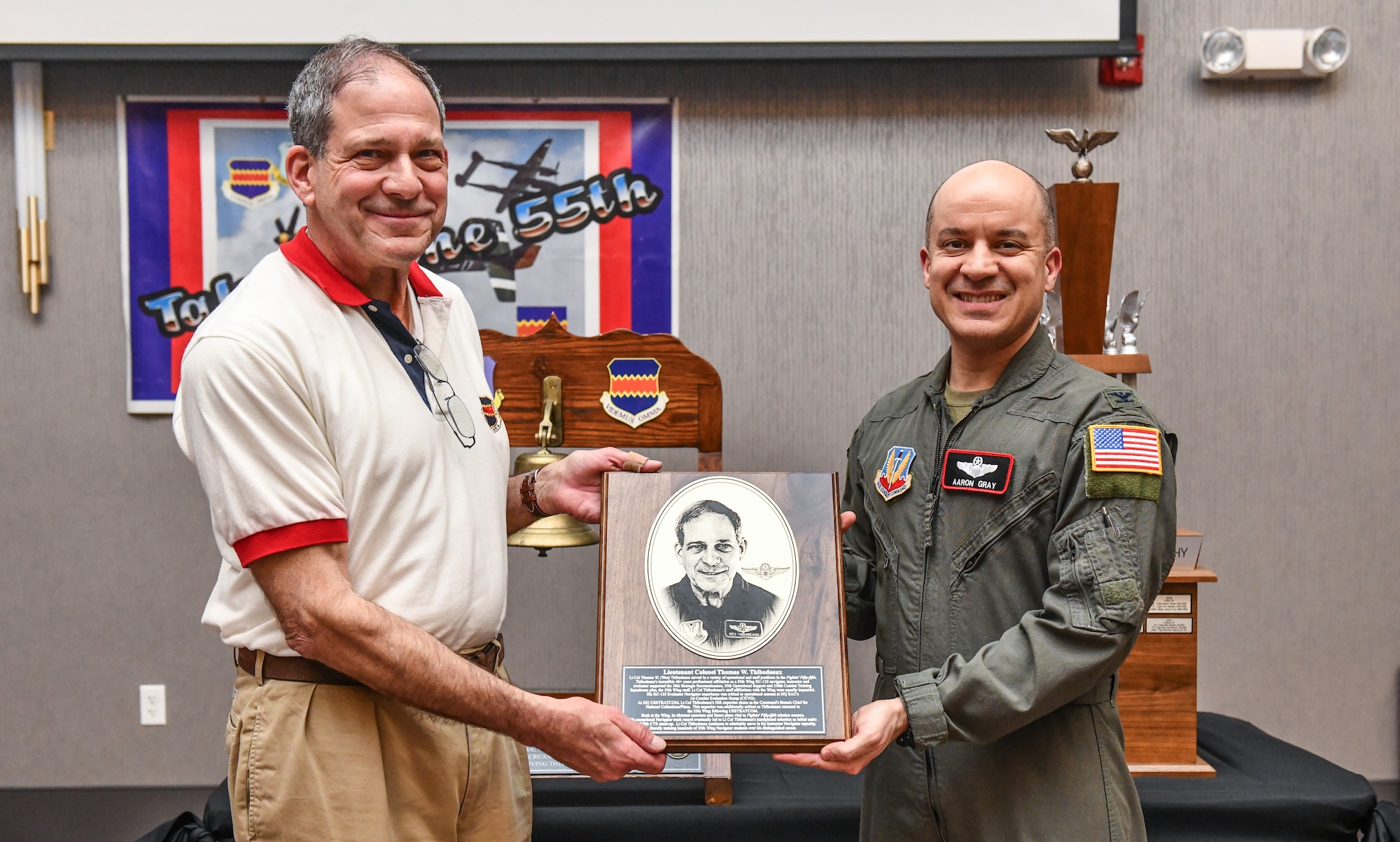 Retired Lt. Col Thomas Thibodeaux recieves his 55th Wing hall of fame plaque from Col. Aaron Gray, 55th Wing deputy commander, at the annual Tales of the 55th event at the Beardmore Event Center in Bellevue, Nebraska on March 27. The annual event was established in 1999 by retired Lt. Col. Robb Hoover as a way for wing veterans to share their personal experiences with former and current members. (U.S. Air Force photo by Chad Watkins)