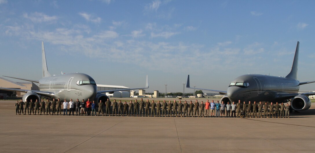 U.S. Marines with Marine Transport Squadron 1 (VMR-1), Marine Air Group 41, 4th Marine Air Wing, Marine Forces Reserve, and Department of Defense (DoD) Civilians, pose for a group photo at Naval Air Station Joint Reserve Base (NAS-JRB) Fort Worth, Texas, on October 4, 2024. VMR-1 provides vital airlift and logistical support, facilitating the movement of personnel, equipment, and supplies for various training and operational missions. (U.S. Marine Corps photo by Sgt. Kree Laing)
