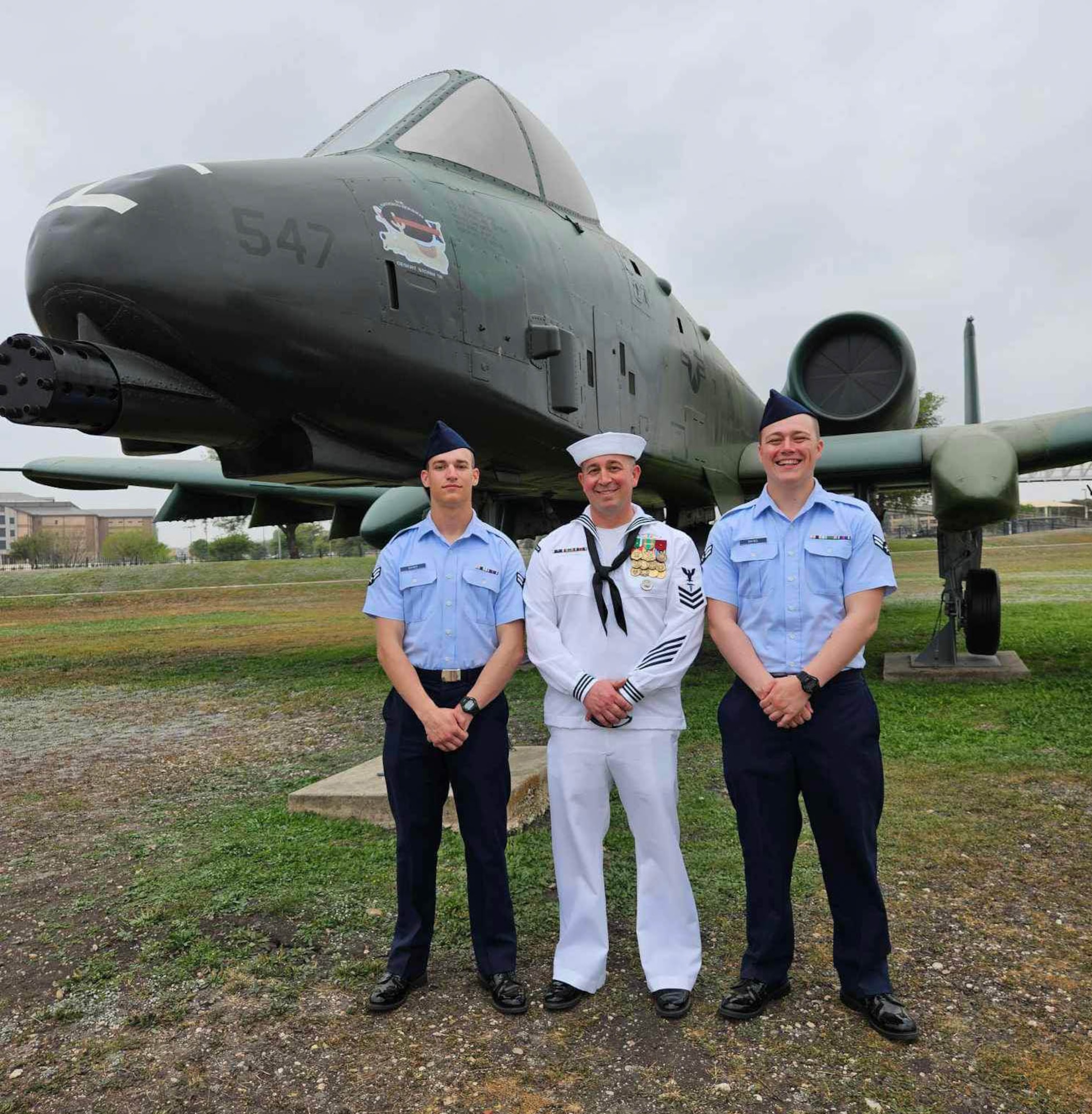 Airman 1st Class Wesley Davies (left), Hospital Corpsman First Class Corey Davies (middle) and Airman 1st Class Owen Davies (right) pose for a picture in front of a A-10 Thunderbolt II after graduating Air Force Basic Training. (Courtesy photo)
