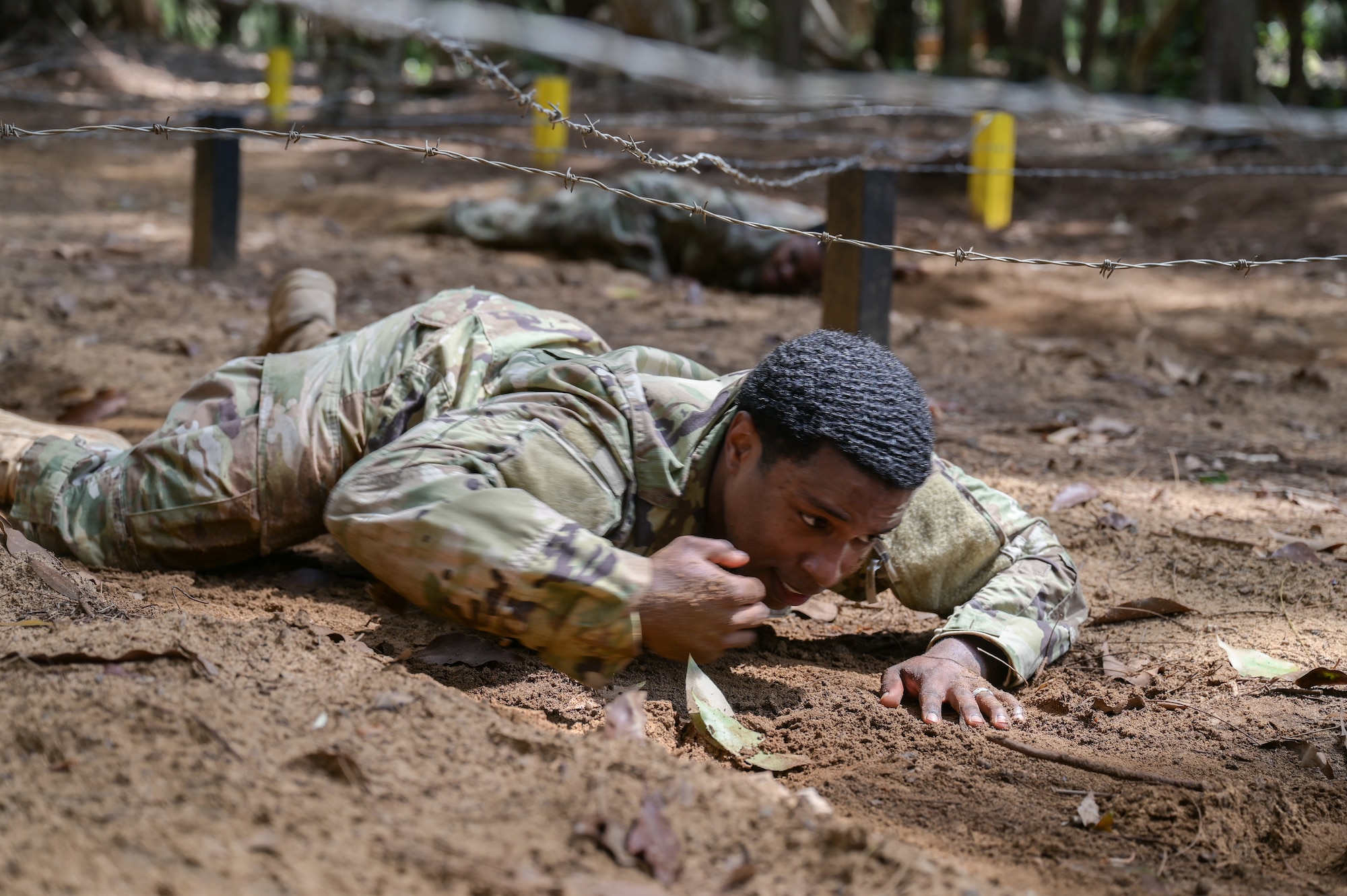Airman crawling in the dirt.