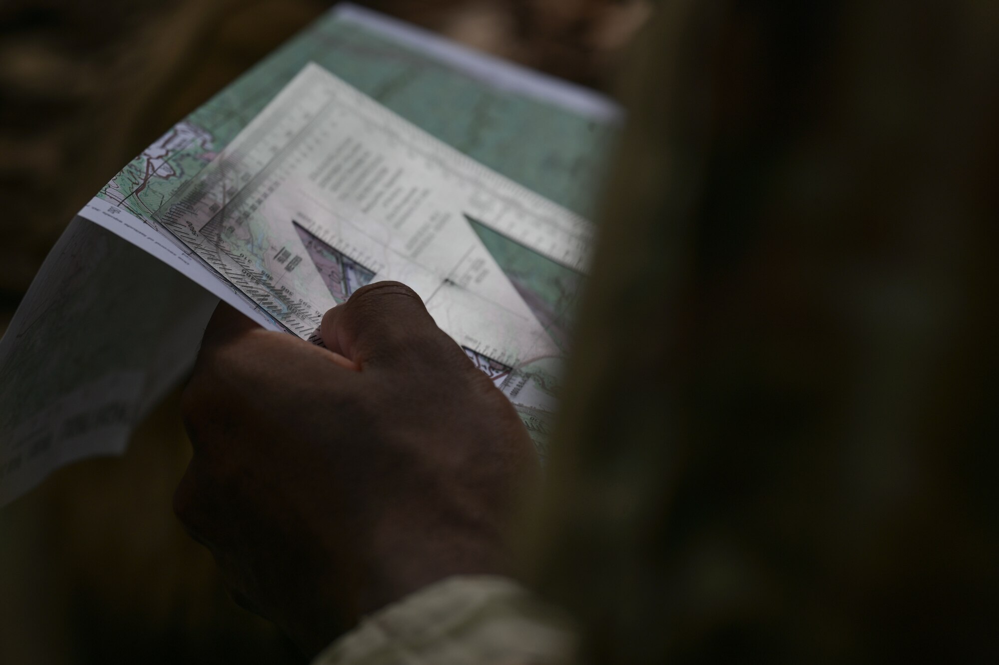 Airman holding a map and a protractor.