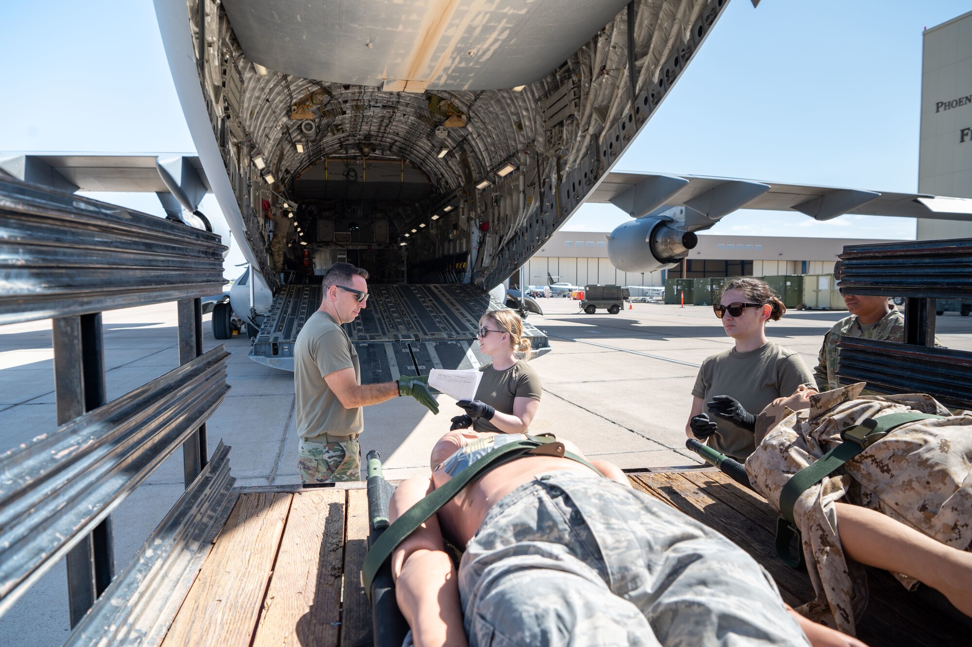 Reserve Citizen Airmen, 944th Aeromedical Staging Squadron, transfer custody of a simulated patients during an aeromedical evacuation training event at Phoenix-Goodyear Airport in Goodyear, Ariz., April 17, 2025. The training, conducted aboard a C-17 Globemaster III from Joint Base Lewis-McChord, Washington, enhanced readiness, improved interoperability and prepared participants for patient movement in high-stress environments. (U.S. Air Force photo by Staff Sgt. Alexis Orozco)