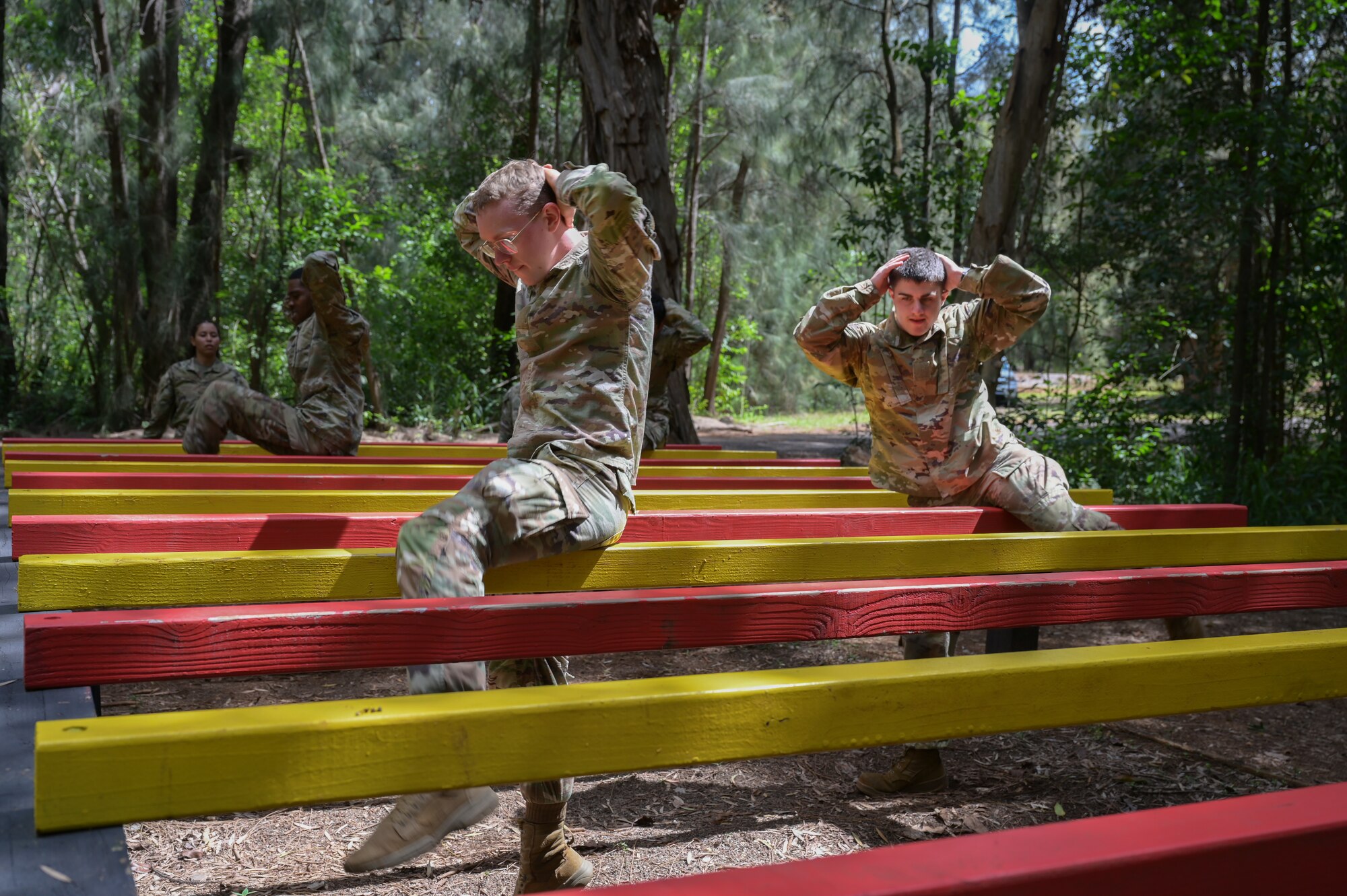 Airmen performing step overs during an obstacle course.