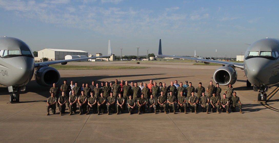 U.S. Marines with Marine Transport Squadron 1 (VMR-1), Marine Air Group 41, 4th Marine Air Wing, Marine Forces Reserve and Department of Defense (DoD) Civilians, pose for a group photo at Naval Air Station Joint Reserve Base (NAS-JRB) Fort Worth, Texas, on October 4, 2024. VMR-1 provides vital airlift and logistical support, facilitating the movement of personnel, equipment, and supplies for various training and operational missions. (U.S. Marine Corps photo by Sgt. Kree Laing)
