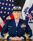 A photo of RADM List in front of the U.S. and USCG flags.