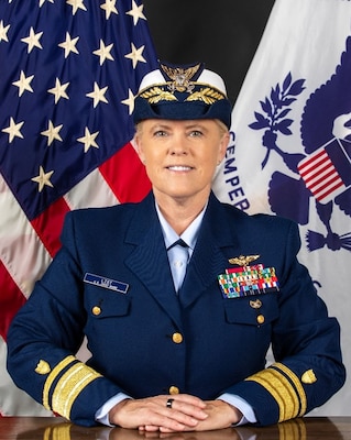 A photo of RADM List in front of the U.S. and USCG flags.