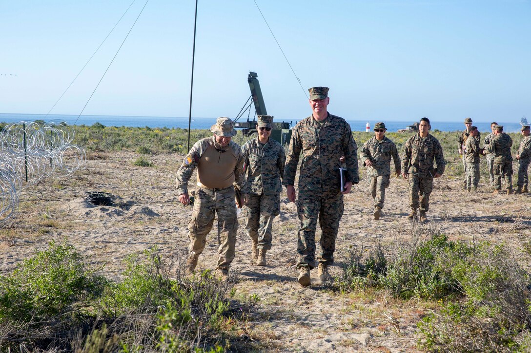 U.S. Marine Corps Col. Ryan Allen, commanding officer of Marine Air Control Group 48, Sgt. Melissa Rivas Casanova, walk with Chilean Marine Col. Francisco Cabezon Gonzalez through Expeditionary Advanced Base North, in Puerto Aldea, Chile, on Sept. 6, 2024, after a meeting about how the following days simulated amphibious raid practice will occur on Sept. 6, 2024, during UNITAS LXV. The simulated amphibious raid practice taking place on Sept. 7, 2024, is meant to prepare U.S. Marine Corps and Chilean units for the simulated raid taking place later on in the week. UNITAS, which is Latin for “unity”, was conceived in 1959 and has taken place annually since first conducted in 1960. This year marks the 65th iteration of the world’s longest running annual multinational maritime exercise. (U. S. Marine Corps photo by Lance Cpl. Payton Goodrich)