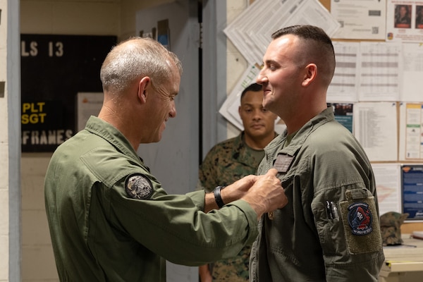 U.S. Marine Corps Maj. Gen James Wellons, left, commanding general, 3rd Marine Aircraft Wing (MAW) awards Staff Sgt. Nicholas Bevan, right, airframes mechanic, MALS-13, 3rd MAW at  Marine Corps Air Station Yuma, Arizona, Oct. 9, 2024. Bevan received the Navy and Marine Corps Achievement Medal (NAM) for designing a 3D printable maintenance tool that will be used to help maintain aircrafts for years to come.  (U.S. Marine Corps photo by Lance Cpl. Elizabeth Gallagher)