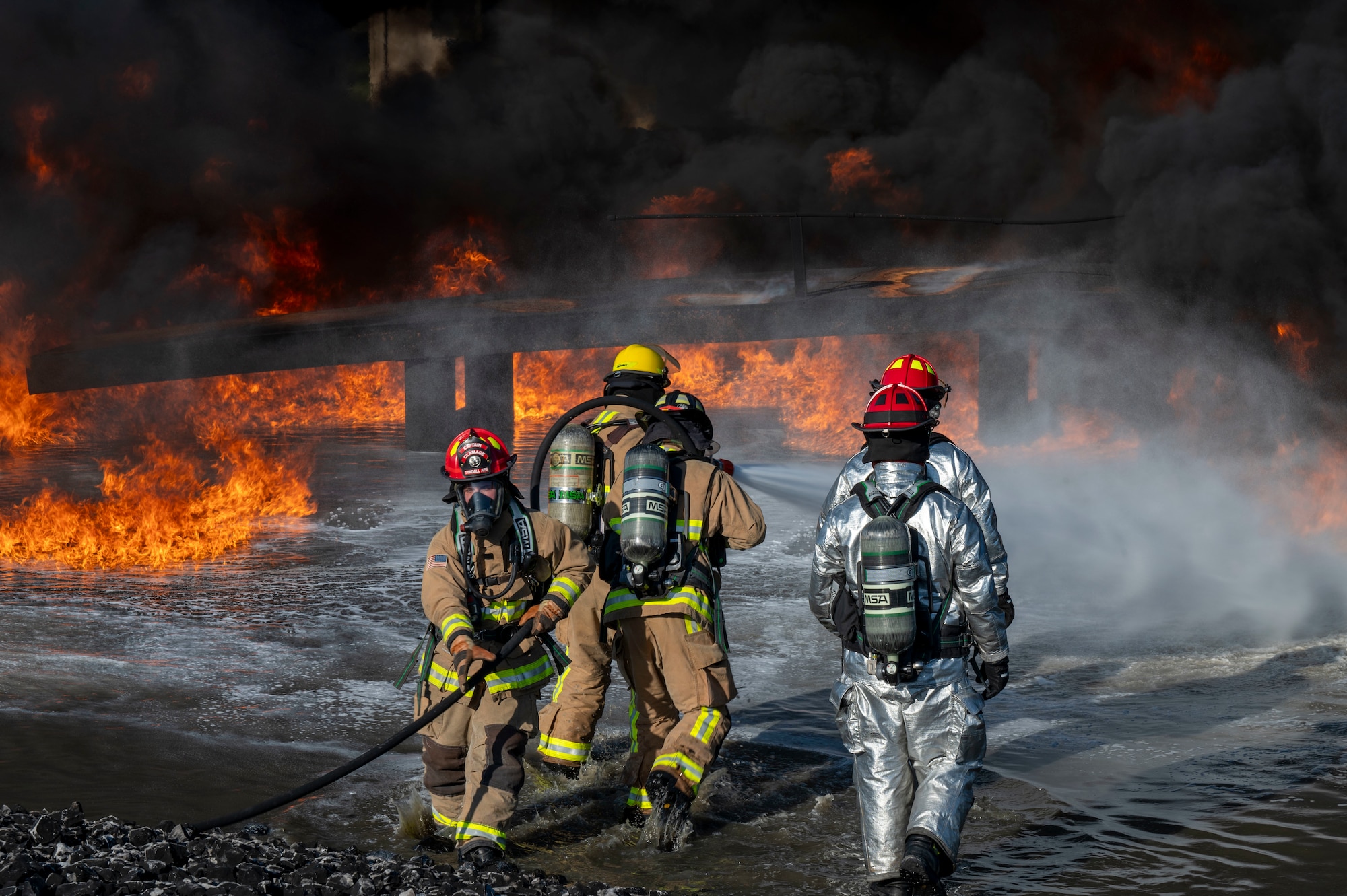 U.S. Air Force fire protection specialists, assigned to the 22nd Air Task Force, practice putting out a jet fuel related fire during a Silver Flag exercise at Tyndall Air Force Base, Florida, April 9, 2025. Aircraft Rescue and Firefighting Training is a biannual certification training that equips firefighters with the knowledge and skills to respond to aircraft emergencies. Air Task Forces will allow the Air Force to provide a definable unit of action that has worked and trained together throughout the AFFORGEN cycle. (U.S. photo by Airman 1st Class Samantha Thorn)