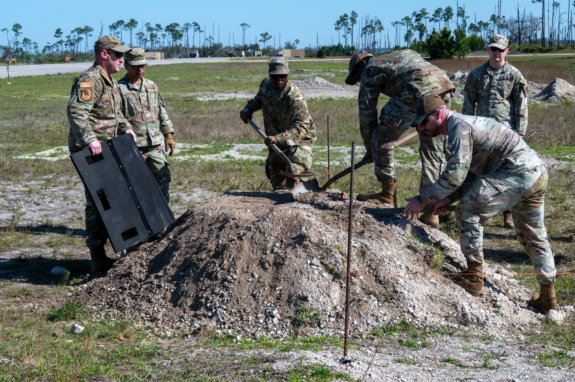 U.S. Air Force Airmen, assigned to the 22nd Air Task Force, level the area to set up approach lights during a Silver Flag exercise at Tyndall Air Force Base, Florida, April 9, 2025. Approach lights provide visual guidance for aircraft to ensure safe landing procedures. This exercise was designed to evaluate and enhance the operational skills of 22nd Air Task Force, ensuring that they are an agile and responsive asset within our Air Force. (U.S. photo by Airman 1st Class Samantha Thorn)