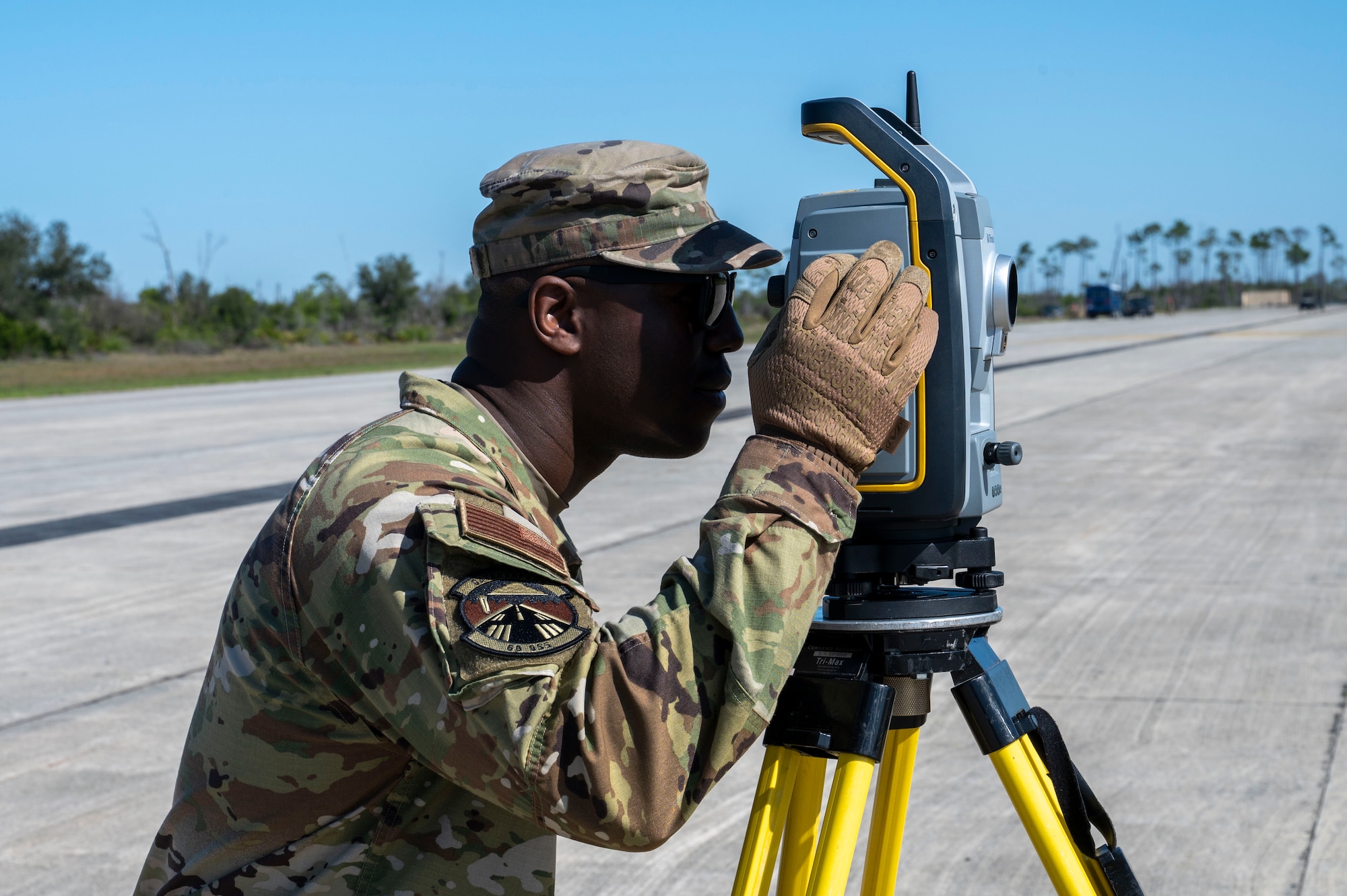 U.S. Air Force Tech Sgt. Kevin Moncrief, an air traffic control specialist assigned to the 22nd Air Task Force, utilizes a survey total station during a Silver Flag exercise at Tyndall Air Force Base, Florida, April 9, 2025. A survey total station is an electronic surveying instrument that measures distance and elevation. This exercise was designed to evaluate and enhance the operational skills of the 22nd Air Task Force, ensuring that they are an agile and responsive asset within our Air Force. (U.S. photo by Airman 1st Class Samantha Thorn)