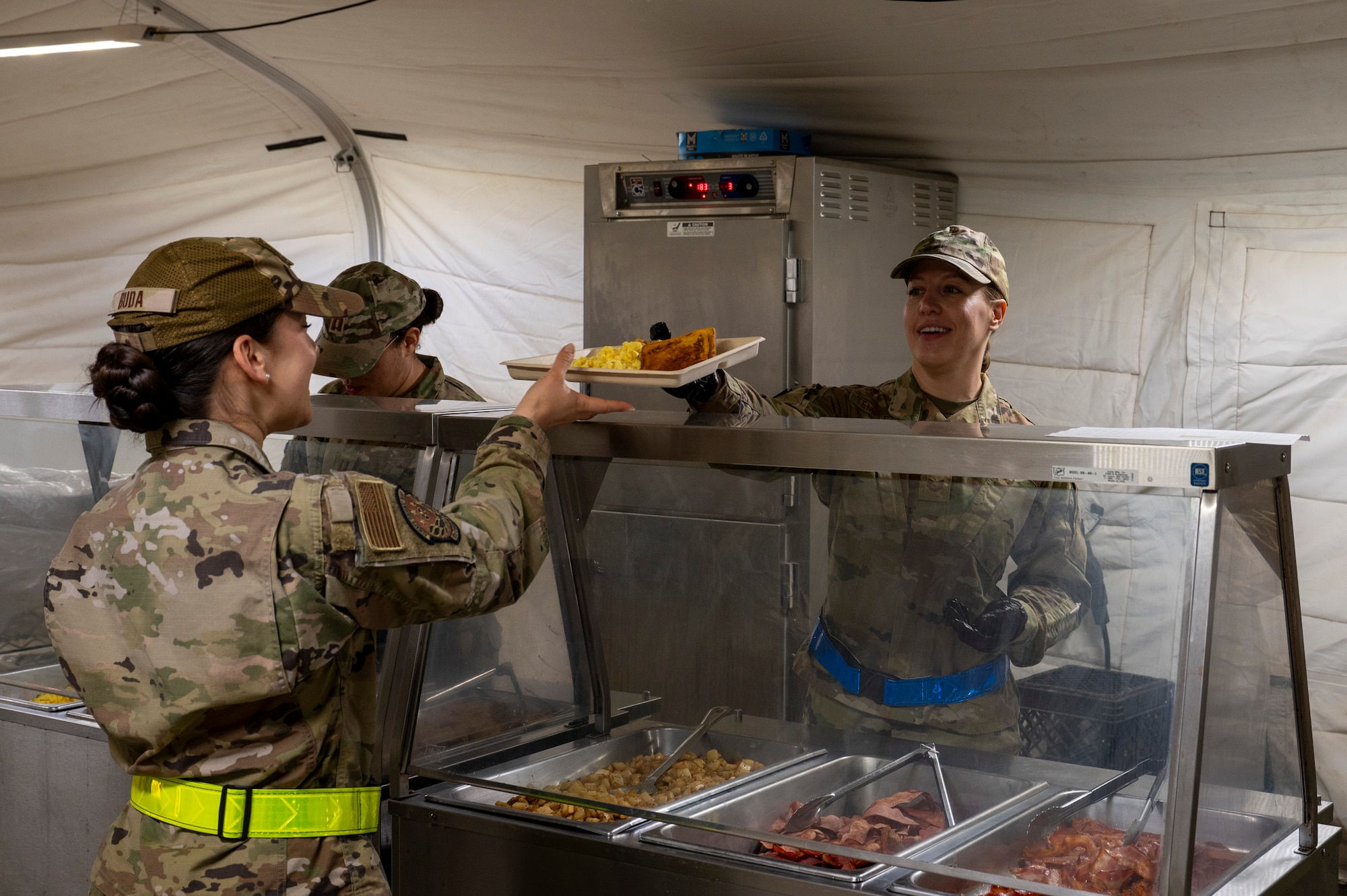 U.S. Air Force Tech. Sgt. Patience Templeton, food section chief assigned to the 22nd Air Task Force, serves food to Airmen during a Silver Flag exercise at Tyndall Air Force Base, Florida, April 10, 2025. This exercise was designed to evaluate and enhance the operational skills of 22nd ATF, ensuring that they are an agile and responsive asset within our Air Force. (U.S. photo by Airman 1st Class Samantha Thorn)