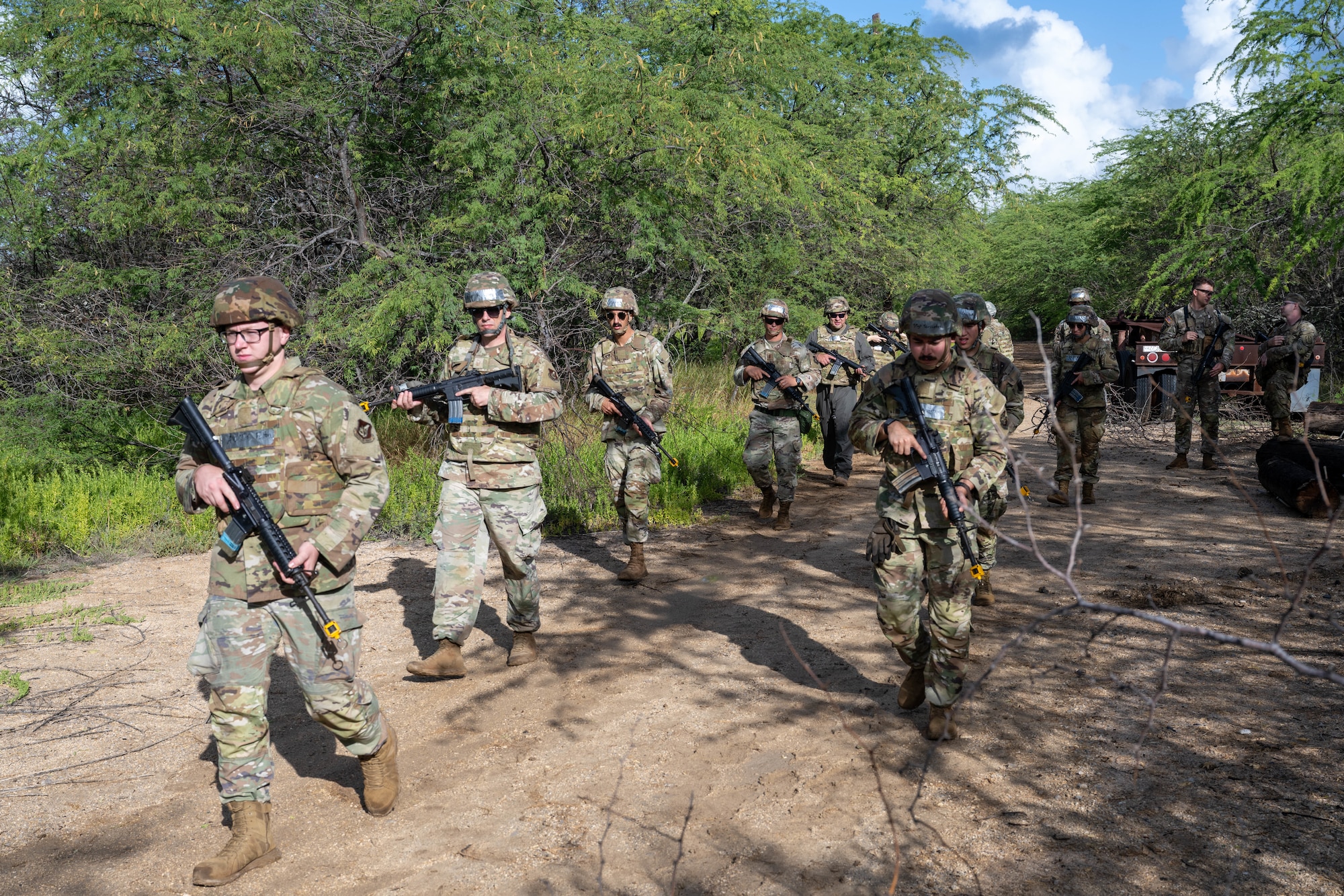 U.S. Air Force Airmen are on foot patrol in the woods with their M4 assault rifles during a training session.