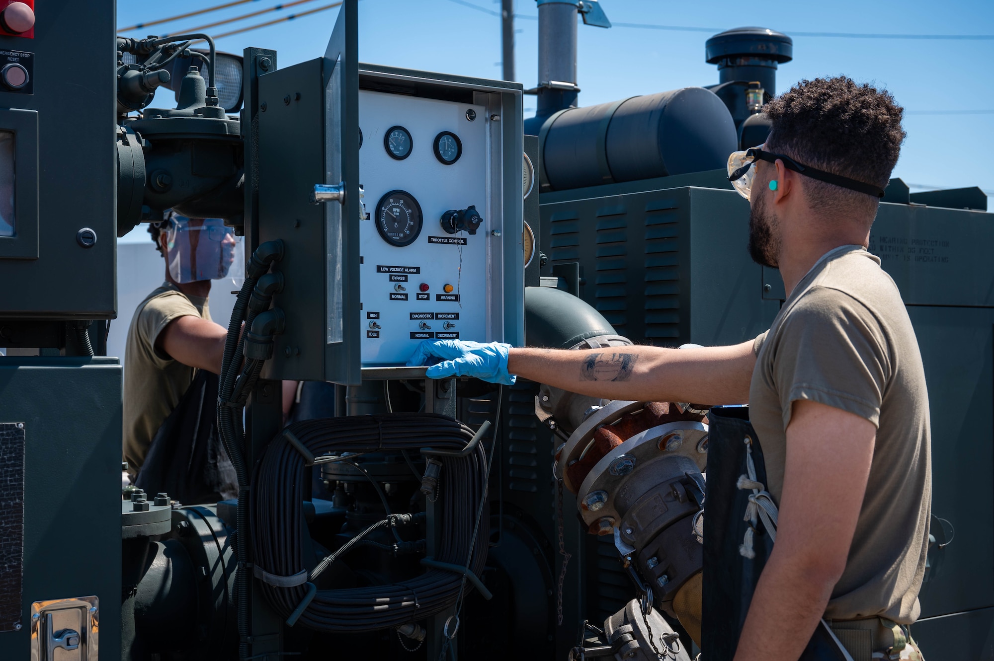 U.S. Air Force Senior Airman Ronald Perry, left, and Senior Airman Blake Torres, 374th Logistics Readiness Squadron war reserve materiel technicians, monitor equipment levels.