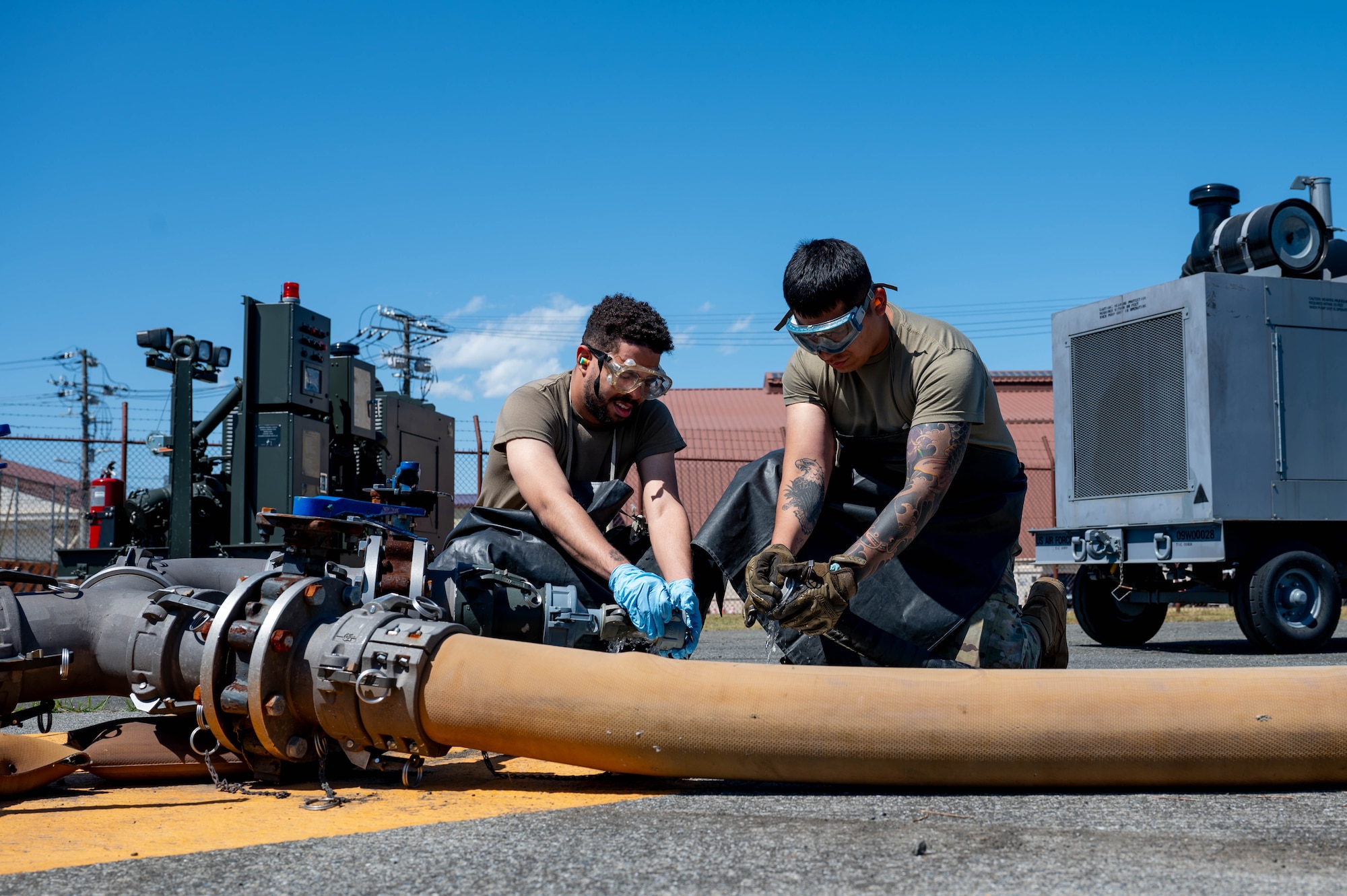 U.S. Air Force Senior Airman Blake Torres, left, and Airman 1st Class Juan Aparicio, 374th Logistics Readiness Squadron war reserve materiel technicians, connect a fuel hose.