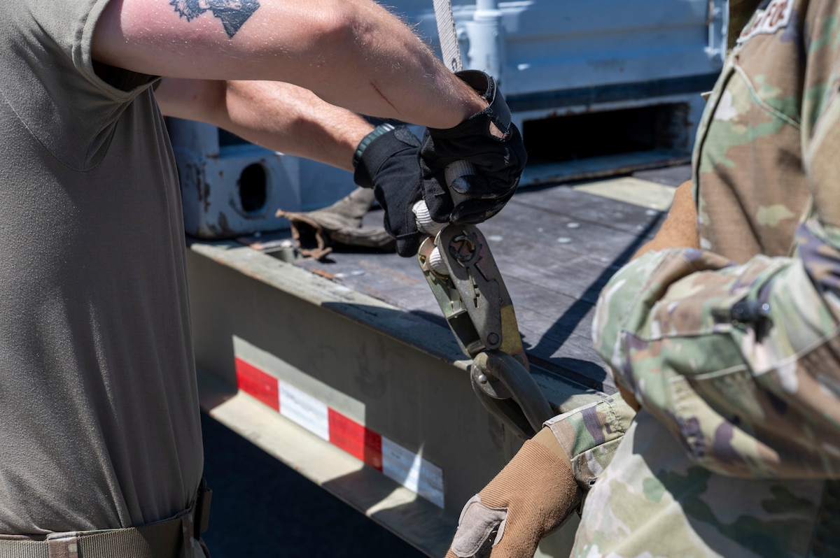 U.S. Air Force Airmen assigned to the 22nd Air Task Force, wrap up the loose end of a ratchet strap during exercise MAGPIE at Tyndall Air Force Base, Florida, April 14, 2025. The 22nd ATF participated in rigorous exercises and diverse training programs to ensure that ATFs are fully prepared to execute assigned missions. (U.S. photo by Airman 1st Class Samantha Thorn)