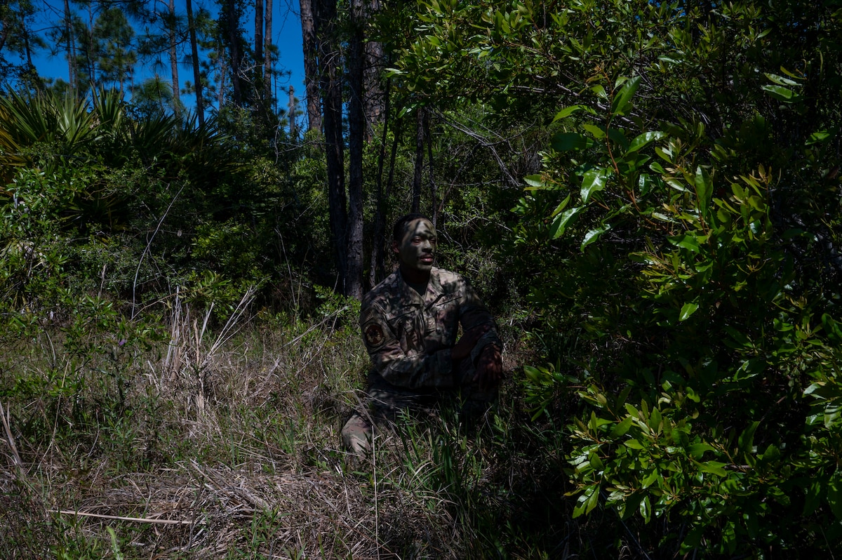 U.S. Air Force Senior Airman Vaughn Anatole Clauzel, an electric power production specialist assigned to the 22nd Air Task Force, tests the effectiveness of camouflage face paint during exercise MAGPIE at Tyndall Air Force Base, Florida, April 13, 2025. Exercises like MAGPIE will continue to propel the 22nd ATF to operate effectively under stressful conditions in contested environments, resulting in a diverse force of Airmen prepared to undertake mission requirements. (U.S. photo by Airman 1st Class Samantha Thorn)