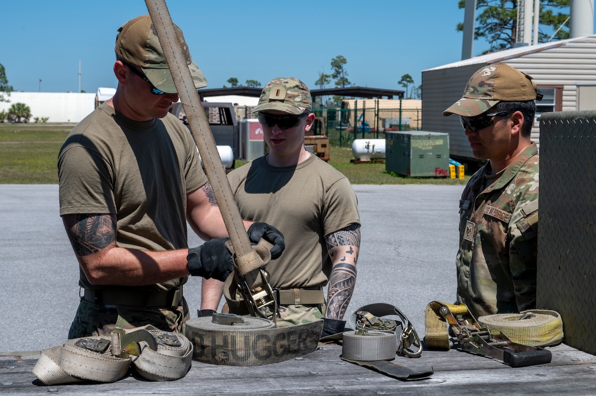 U.S. Air Force Airmen assigned to the 22nd Air Task Force, tighten down a ratchet strap during exercise MAGPIE at Tyndall Air Force Base, Florida, April 14, 2025. The 22nd ATF participated in rigorous exercises and diverse training programs to ensure that ATFs are fully prepared to execute assigned missions. (U.S. photo by Airman 1st Class Samantha Thorn)