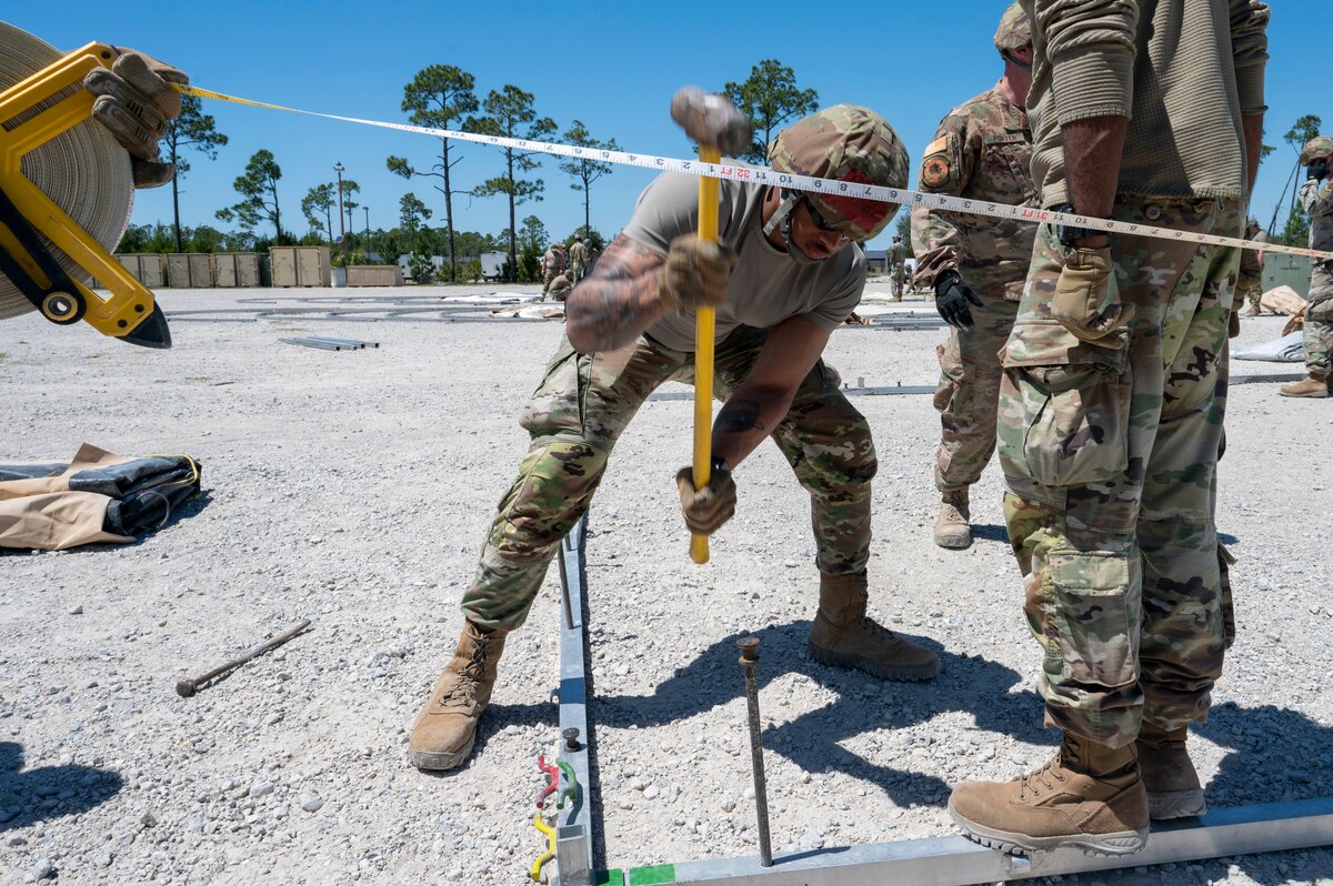U.S. Air Force Airman 1st Class Henry Leon, an emergency management technician assigned to the 22nd Air Task Force, uses a sledgehammer on a stake during exercise MAGPIE at Tyndall Air Force Base, Florida, April 13, 2025. Exercises like MAGPIE will continue to propel the 22nd ATF to operate effectively under stressful conditions in contested environments, resulting in a diverse force of Airmen prepared to undertake mission requirements. (U.S. photo by Airman 1st Class Samantha Thorn)