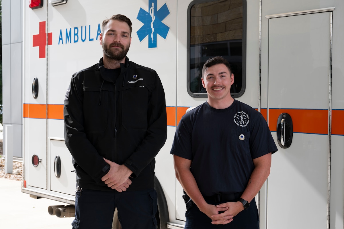 Air Force paramedics pose in front of ambulance