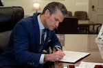 A man signs a document.