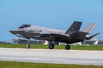 An aircraft lands on the flight line.