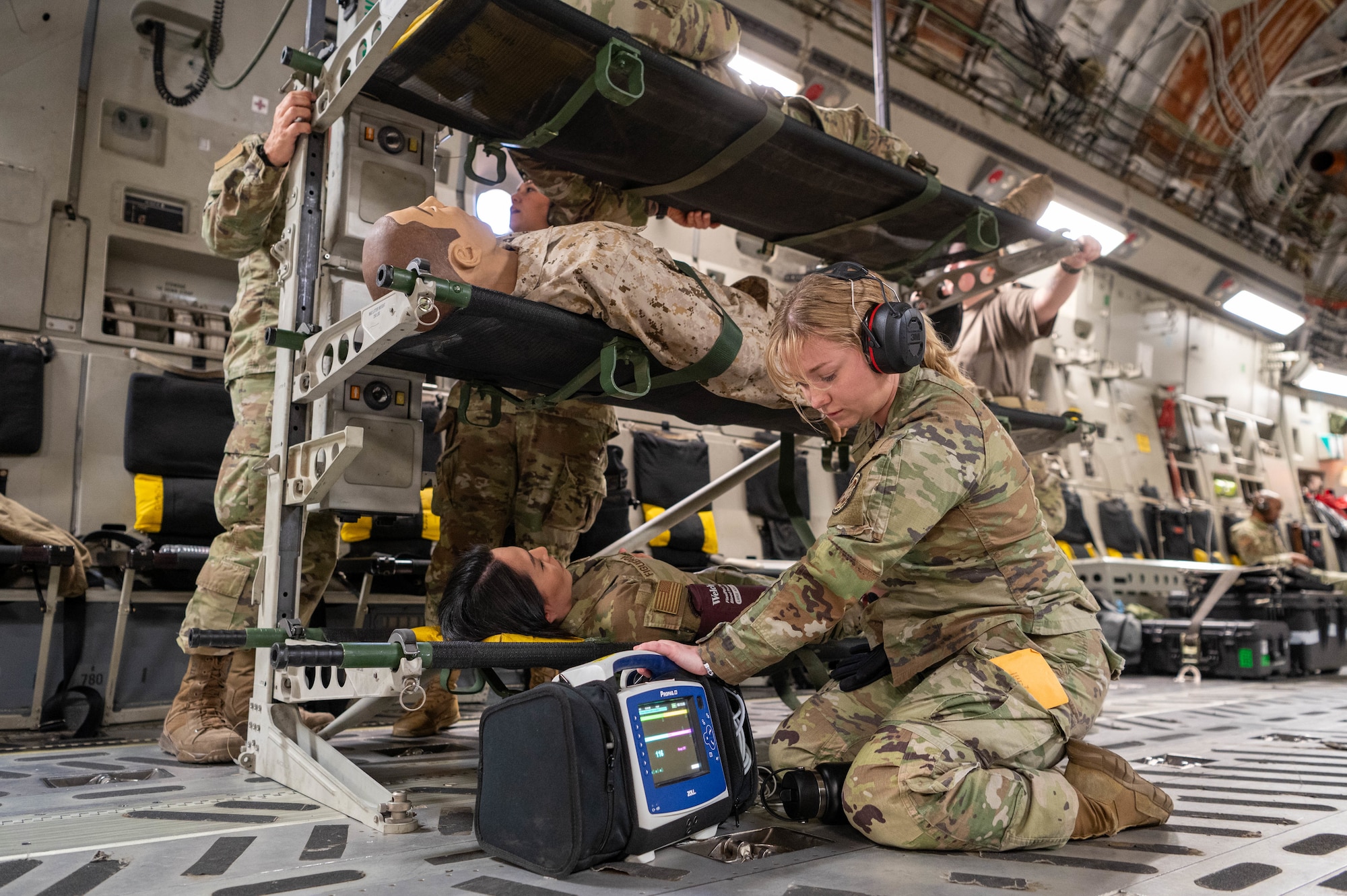 Reserve Citizen Airmen, 944th Aeromedical Staging Squadron, provide patient care during a simulated aeromedical evacuation training event aboard a C-17 Globemaster III flying nearby Nellis Air Force Base, Nev., April 16, 2025. The training, conducted aboard a C-17 from Joint Base Lewis-McChord, Washington, enhanced readiness, improved interoperability and prepared participants for patient movement in high-stress environments. (U.S. Air Force photo by Staff Sgt. Alexis Orozco)