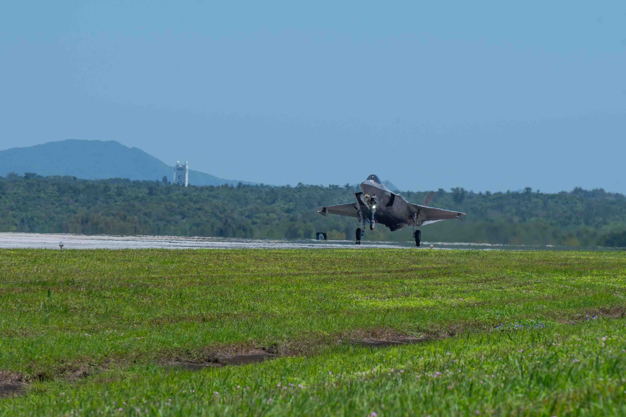 An aircraft lands on the flight line.