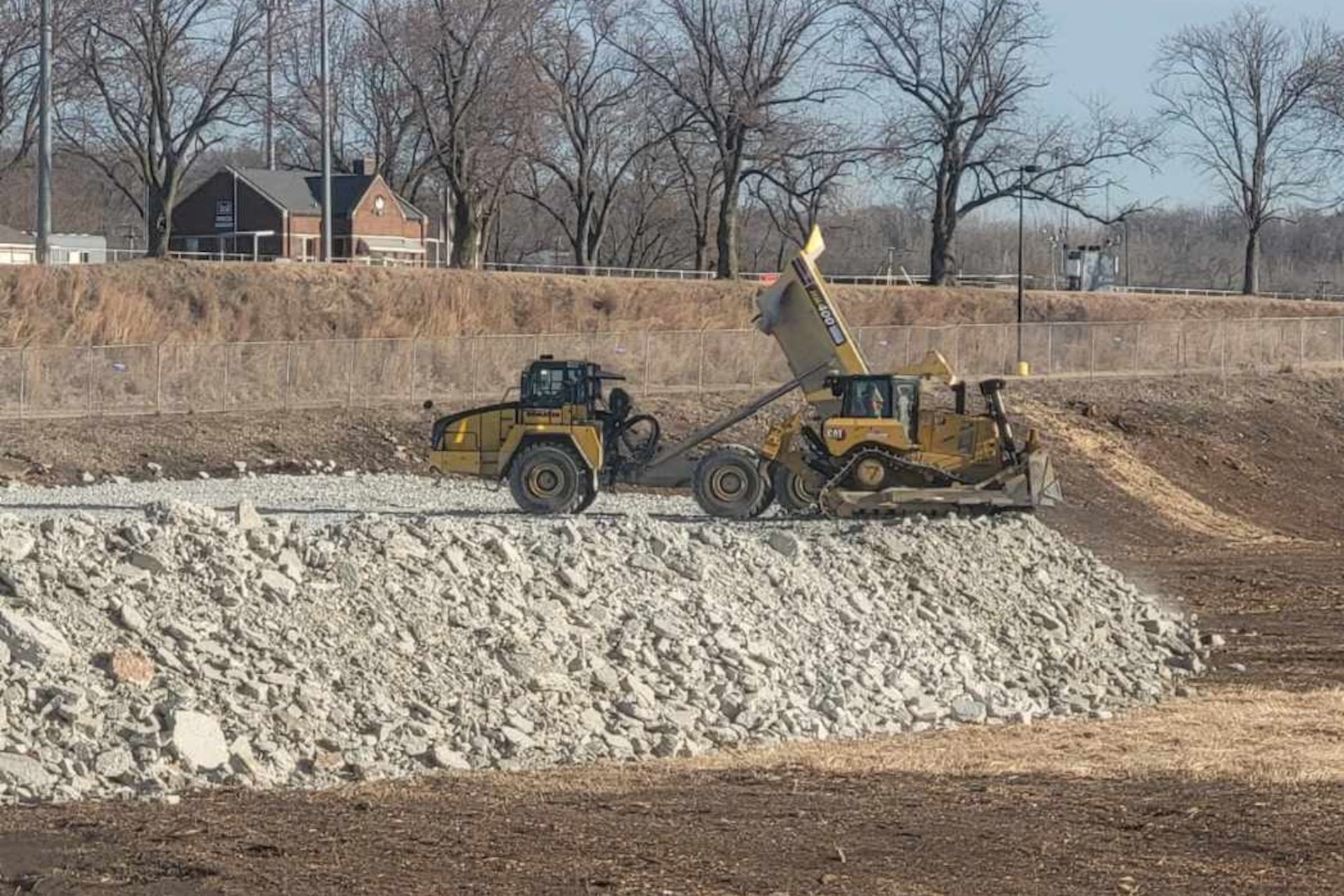 Contractors for the Brandon Road Interbasin Project place rock excavated from the channel of Illinois Waterway on the south side of the Brandon Road Lock to build access roads for future construction access needs.