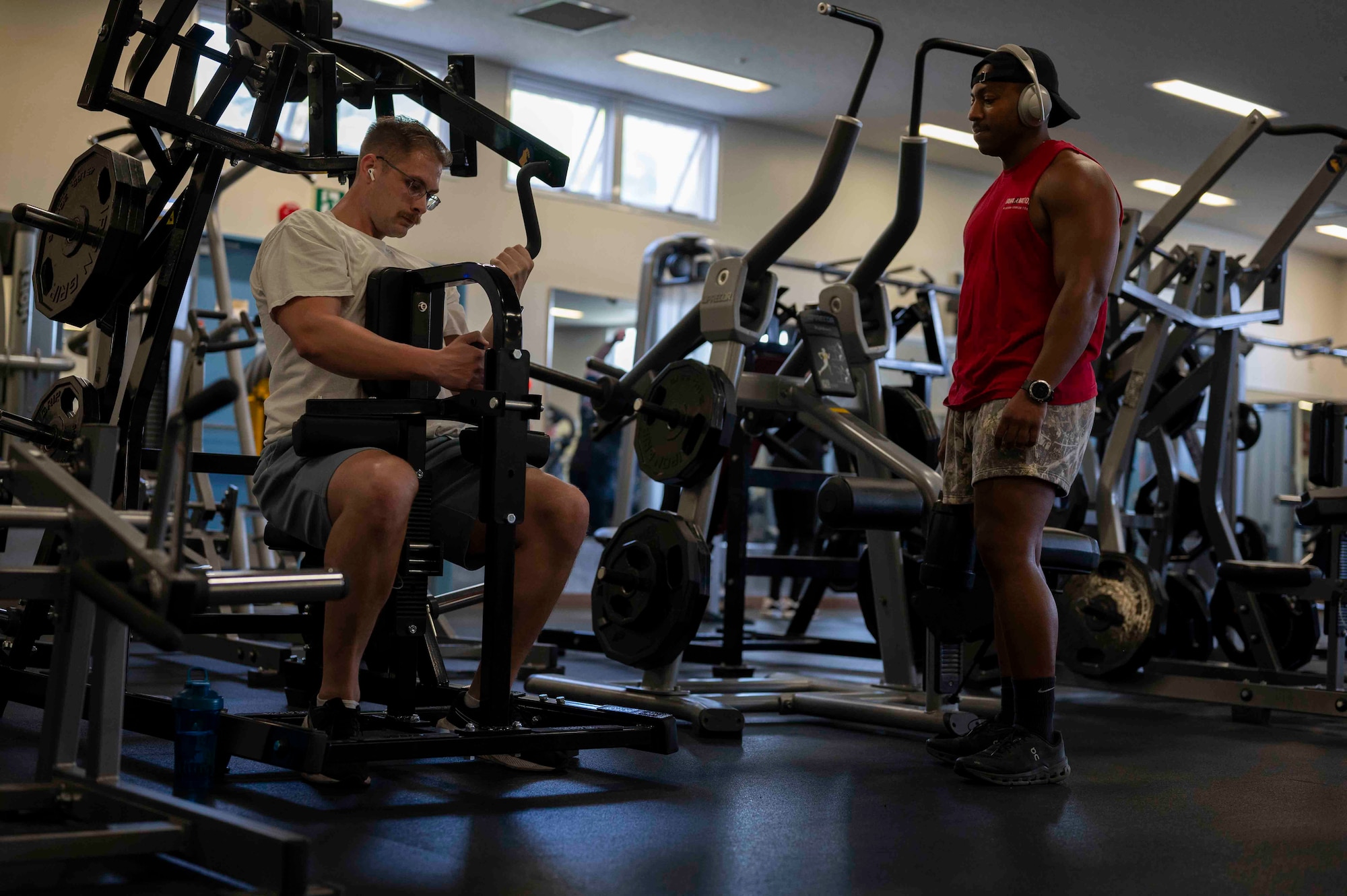 Two military members workout on new exercise equipment.